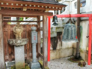 Next to the main building are a bell and a statue of Hotei, one of the Seven Lucky Gods