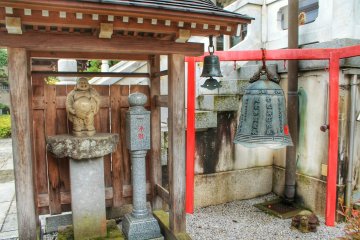 Next to the main building are a bell and a statue of Hotei, one of the Seven Lucky Gods