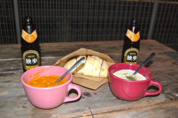 Bowls of chowder and chicken curry with sour dough bread and beer