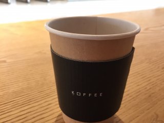 The coffee is served in a beautifully designed minimalist cup.
