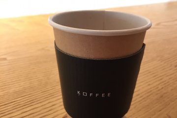 <p>The coffee is served in a beautifully designed minimalist cup.</p>
