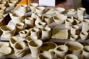 Pottery pieces made by visitors, waiting to be fired and glazed.