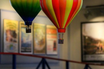 Colorful balloons hang above the miniature town