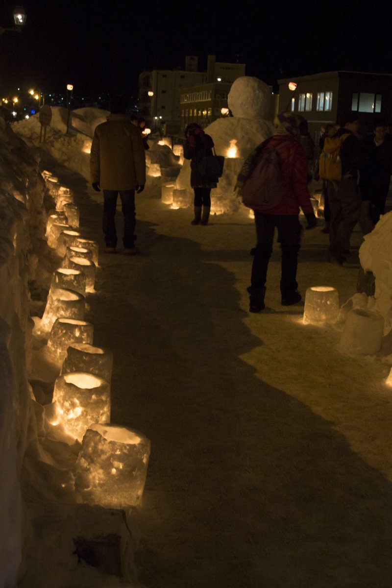 Candlelit path leading to a giant snowman