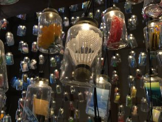 Memory Bottle by Mayumi Kuri features a very large collection of jars suspended from the ceiling, each filled with a memory from an island resident.