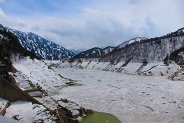 A majestic scene of the Kurobe Lake blanketed in snow 