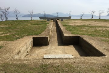 #84 Garden of the Border by Mitsuharu Doi is a sunken Torii gate, like something recently excavated and quite the opposite of the floating Torii gate at Miyajima near Hiroshima