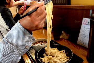 Lifting the cold noodles into the hot soup