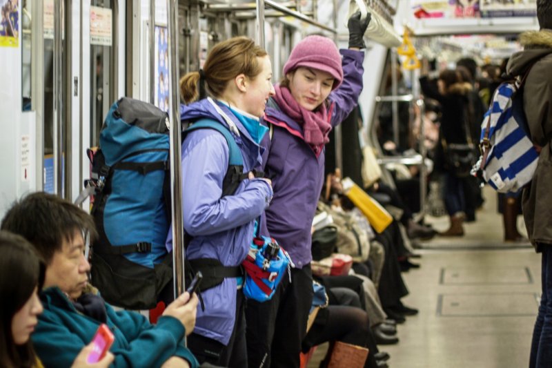 On the subway in Sapporo with hiking packs on 