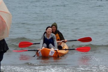 A couple laugh as they head back to shore after trying out kayaking