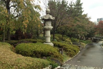 Traditional stone lanterns guard the walkways at Tokugawa-En