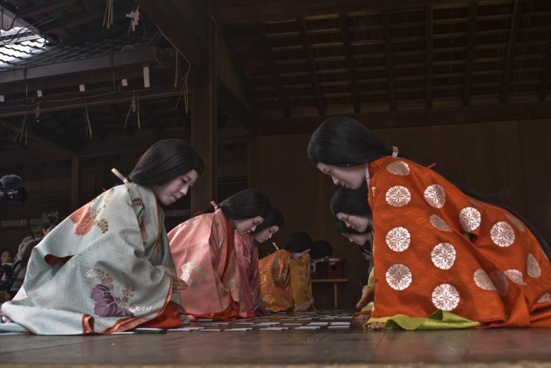 주니 히또에를 입은 여성들이 카루타 게임을 즐긴다