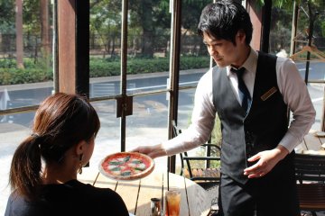 Server presenting a lunch pizza