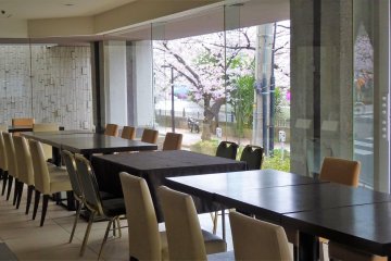 ห้องอาหารมีหน้าต่างกระจกจรดพื้นบานใหญ่ เปิดโอกาสให้ชมวิวแม่น้ำและดอกซากุระ