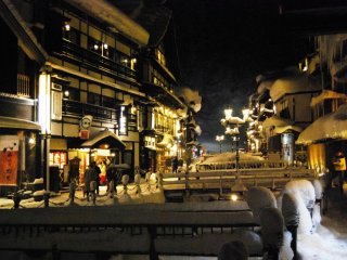 The yellow light from gas lanterns creates a romantic atmosphere at Ginzan Onsen