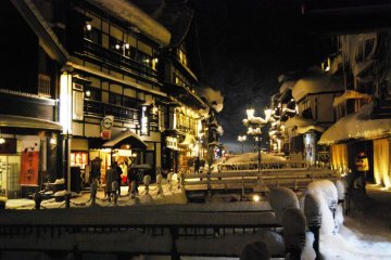 The yellow light from gas lanterns creates a romantic atmosphere at Ginzan Onsen