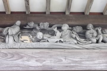 A carved diorama under the eaves of the worship hall