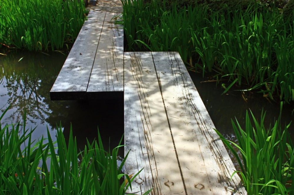 A simple bridge of wooden planks allows visitors to cross this small stream.