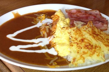 <p>The chili omelet is a cheese omelet served with rice, hash browned potatoes, bacon, rice and sour cream</p>