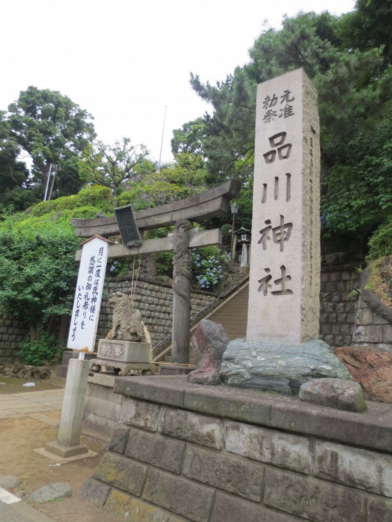 Shinagawa Shrine stone tablet and a sign encouraging people to come once a month