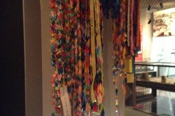 1000 paper cranes hang silently. With any luck their prescence should bring peace to those that have passed and those that endured the unendurable.