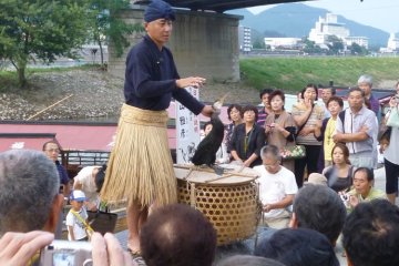 Traditional cormorant fisherman explains his craft to the crowds