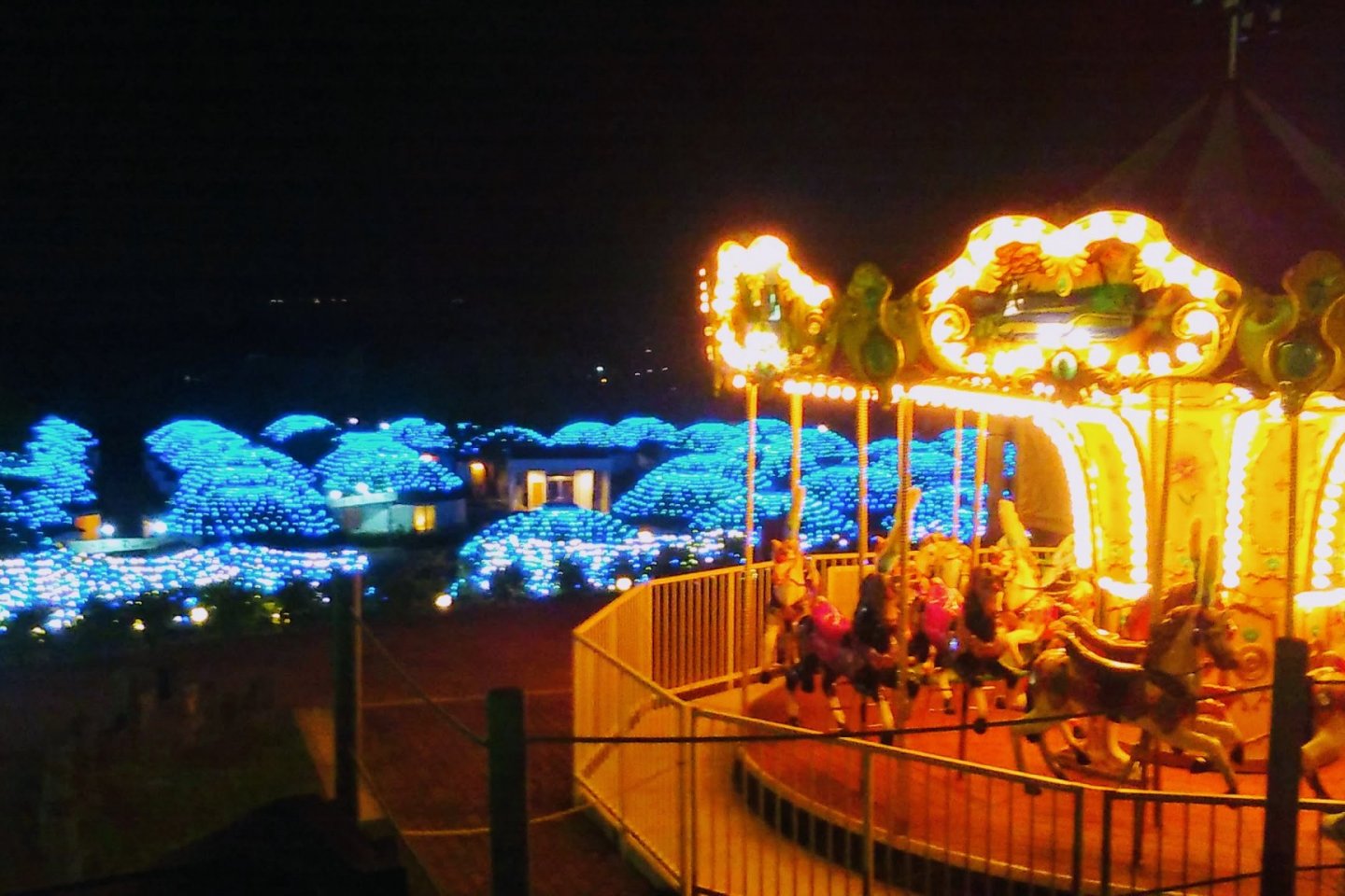 Carousel and yurts lit up at night