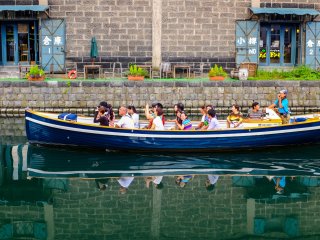 Pantulan aula Otaru Beer dan turis-turis penuh semangat di air kanal