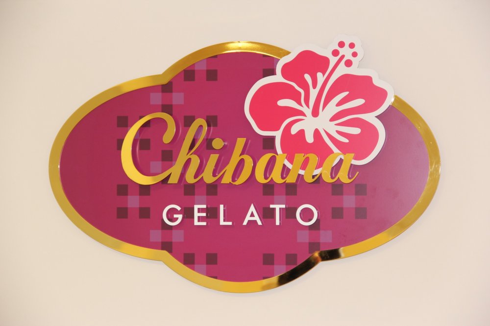 Logo hình bông hoa màu tím và hoa dâm bụt màu đỏ của Chibana Gelato biểu tượng cho các hương vị lấy cảm hứng từ thiên nhiên.