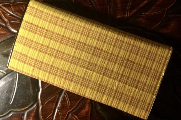 The distinctive check pattern on this wallet highlights the yellow threads