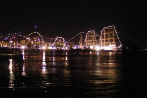 The tall ships are illuminated at night