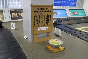 Baggage claim area, complete with a display bowl of sanuki udon, a famous regional dish