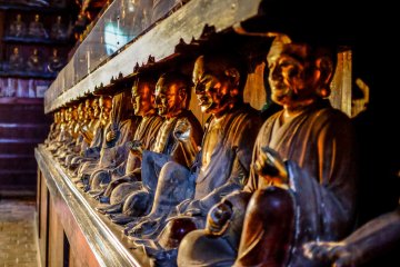 The Buddhist statues line the left and right side walls, each statue represented by a different face and gesture