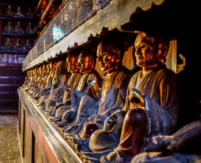 The Buddhist statues line the left and right side walls, each statue represented by a different face and gesture