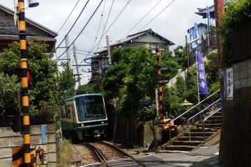 Train passing by right in front of a small temple