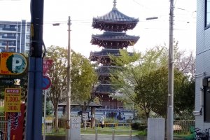 The pagoda of Kosho-ji Temple peeking through two modern buildings