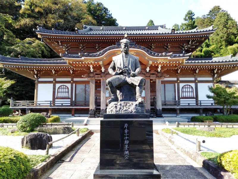 A statue of Katakura sits proudly in front of the temple