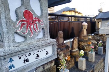 Octopus design lantern in front of Buddhist statues