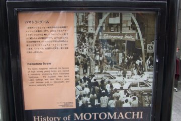 A sign on the street explaining Motomachi's history.