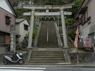Chiếc cổng Torii tách những căn nhà ra và là điểm bắt đầu của những bậc thang leo lên đỉnh núi