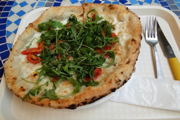 A white pizza with tomatoes and spinach