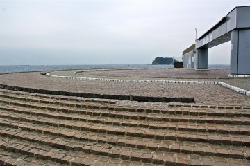 The circular brick area features water fountains for children to splash in