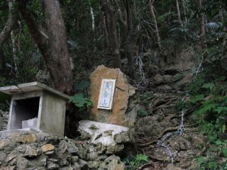 A shrine on the mountain side; ropes in the background lead up a very direct and steep approach up to the nearby mountain peaks