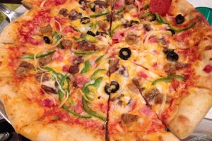 The Surfside Special Pizza is made in Okuma&#39;s outdoor pizza oven and comes with&nbsp;pepperoni, ham, bacon, sausage, peppers, onions, mushrooms and black olives smothered with cheese