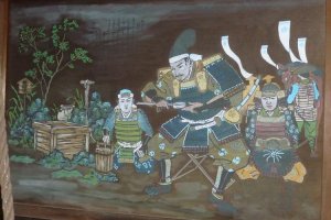 Painted panel showing Nobunaga and his retinue drinking from the well.