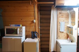 อีกมุมหนึ่งภายในบ้านพัก ทางซ้านเป็นตู้เย็น ไมโครเวฟ กระติกน้ำร้อน และสุดทางเดิน ซ้ายมือเป็นห้องอาบน้ำ และขวามือเป็นห้องสุขา